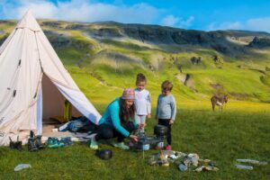 famille en bivouac qui cuisine