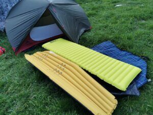 des matelas de camping au sol devant une tente