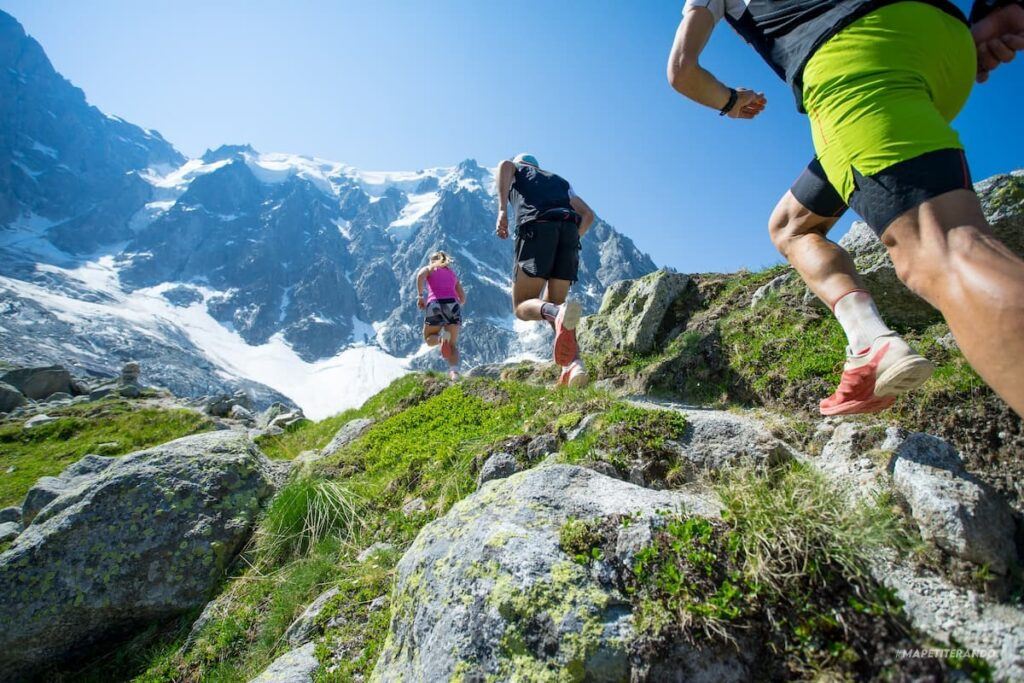 3 personnes qui font du fast hiking en montagne